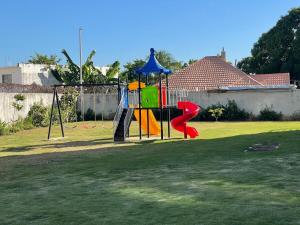 a playground with a slide in a yard at Modern Kingston Apartment Suite With Pool & Ocean View in Kingston