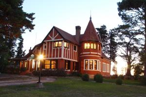 una casa grande con luces encendidas en el patio en Hotel Boutique Villa Art, en La Cumbre