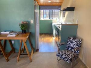 a kitchen with a table and a zebra print chair at Beach Break in Mount Maunganui