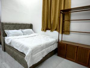 a bedroom with a bed and a window at Chempaka Suite Homestay in Kampong Tok Pakir