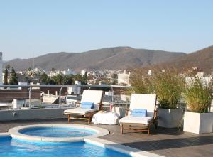 un patio con 2 sillas y una piscina en la azotea en Ayres De Salta Hotel en Salta