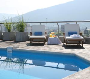 two lounge chairs sitting next to a swimming pool at Ayres De Salta Hotel in Salta