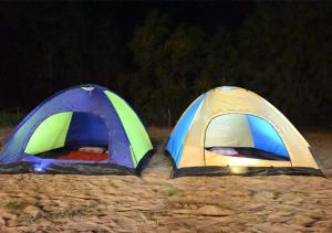 two tents sitting on the beach at night at Gokarna Glimpse Getaway in Gokarna