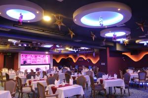 マナーマにあるHoliday Bahrain Hotelのダイニングルーム(テーブル、椅子、ステージ付)