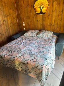 a bed with a comforter in a room at Bungalow Combava in Saint-Pierre