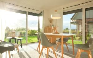 a dining room with a table and chairs and a large window at Himmelsicht in Westerdeichstrich