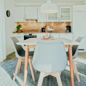 a kitchen with a white table and chairs at Himmelsicht in Westerdeichstrich