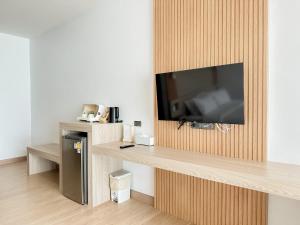 カノムにある2SIS'S Khanom Resotelの木製の壁にテレビ付きのリビングルーム