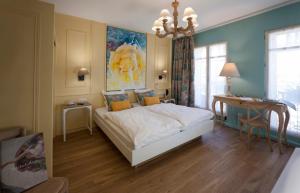 a bedroom with a bed and a desk in it at Hotel Roses in Strasbourg