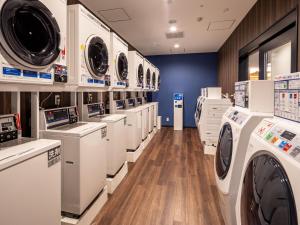 a laundry room with several washers and dryers on display at APA Hotel & Resort Osaka Namba Ekimae Tower in Osaka