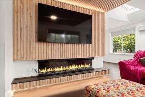 卡尔斯The Green Garden Gate - Phillip Island的客厅设有壁炉,上面配有电视