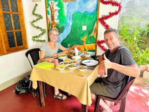 a man and woman sitting at a table with food at Nethmi Homestay & family Restaurant in Tangalle +30 photos