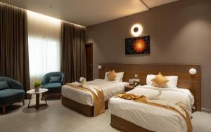 ein Hotelzimmer mit zwei Betten und einem Stuhl in der Unterkunft Sanketam Motel in Kozhikode + 22 Fotos