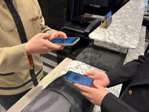 two people holding their cell phones in their hands at APA Hotel & Resort Osaka Namba Ekimae Tower in Osaka