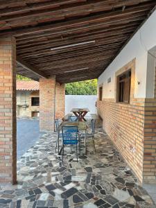 a patio with a table and chairs and a brick wall at Oásis de Férias. in Lucena +10 photos