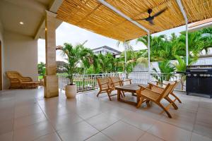 a patio with a table and chairs and trees at great 3-bedroom Villa Near Canggus Top Attractions in Canggu