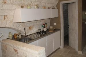 a kitchen with a sink and a stone wall at Dimora Lumi in Locorotondo