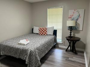 a bedroom with a bed with a table and a window at Sweet Home Alabama 4BR 2BA oasis with pool WI-FI in Montgomery +34 photos