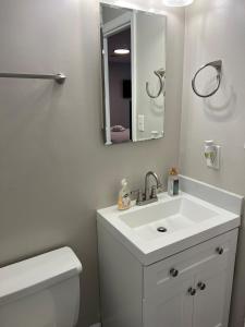 a white bathroom with a sink and a mirror at Sweet Home Alabama 4BR 2BA oasis with pool WI-FI in Montgomery