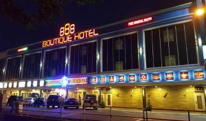 峇株巴轄的住宿－888精品酒店，一家晚上停在外面有车辆的酒店
