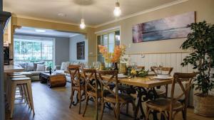 a dining room and living room with a table and chairs at Frazer Place - Thoughtful Country Lodge in Daylesford
