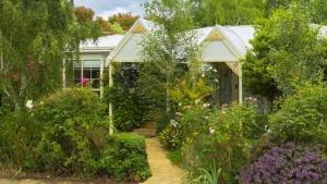 a house with a garden of flowers in front of it at Frazer Place - Thoughtful Country Lodge in Daylesford