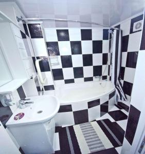a bathroom with a black and white checkered floor at Apartment in City Center, street Banulescu Bodoni 57 in Chişinău