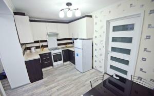 a kitchen with white cabinets and a white refrigerator at Apartment in City Center, street Banulescu Bodoni 57 in Chişinău