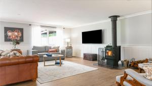a living room with a couch and a fireplace at Grenville Belle Daylesford in Daylesford