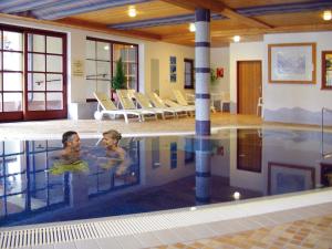 two people swimming in a swimming pool at Gasthof Bad Hochmoos in Lofer