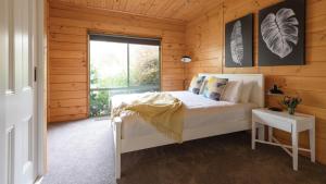 a bedroom with a white bed and a window at Olive Grove in Daylesford