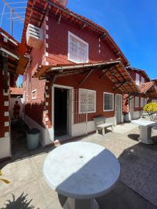塔曼达雷Casa Totonho praia dos Carneiros的红砖楼前的白色桌子