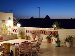 un patio avec des chaises, une table et des plantes dans l'établissement private rooftop with hot jacuzzi and pyramids view, à ‘Ezbet `Abd el-Ḥamîd