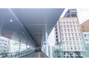 Blick auf ein Gebäude von einem gläsernen Gehweg in der Unterkunft Hotel Areaone Okayama - Vacation STAY 32493v in Okayama
