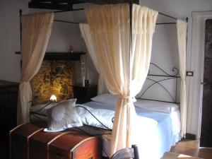 サルソマッジョーレ・テルメにあるAntica Torreのベッドルーム(四柱式ベッド、カーテン付)