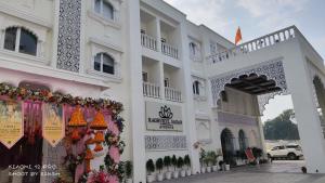 un edificio bianco con un cancello e dei fiori di raghukul sadan a Faizābād