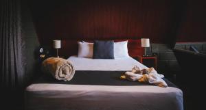 a bedroom with a bed with a stuffed animal on it at Yarumo Lodge, Río Celeste Black Chalets in Bijagua