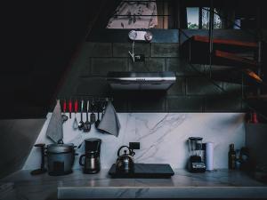 a kitchen counter with utensils and a sink at Yarumo Lodge, Río Celeste Black Chalets in Bijagua