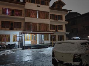 a snow covered parking lot in front of a building at Reshi guest house in Srinagar