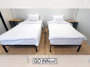 two beds sitting next to each other in a room at GO INN Phuket Old Town ภูเก็ตโอลทาวน์ ย่านเมืองเก่า in Phuket