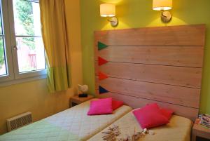 Lagrange Grand Bleu Vacances – Résidence Le Village des Aloès tesisinde bir odada yatak veya yataklar