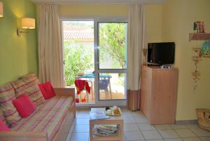 Een TV en/of entertainmentcenter bij Lagrange Grand Bleu Vacances – Résidence Le Village des Aloès
