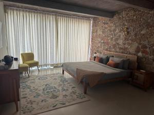 une chambre avec un lit et une grande fenêtre dans l'établissement Kesar Farm House on the Lake, à Udaipur 34 autres photos