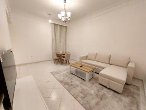 a living room with a couch and a table at HARF22G02-02 stylish 2BR in AD in Abu Dhabi