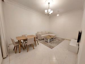 a dining room with a table and a couch at HARF22G02-02 stylish 2BR in AD in Abu Dhabi