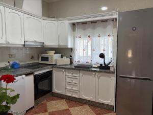 Cañada del RabadánにあるLa Casa del Flamencoの白いキャビネットと冷蔵庫のあるキッチン