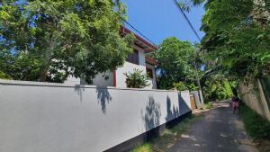 ヒッカドゥワにあるNishu Villa Hikkaduwaの塀の横を歩く女