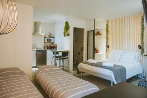 une chambre d'hôtel avec deux lits et une cuisine dans l'établissement Séjour pro & Famille - Gîtes meublés Wood Sky - WIFI Parking privé Terrasses & Jardin, à Laveyron
