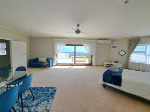 Cape TownGrace Space in Plattekloof的一间卧室，配有一张床、一张桌子和几把椅子