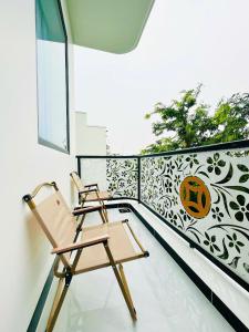 twee stoelen op een balkon met een pompoen-stencilmuur bij Lộc Vừng Homestay in Phan Thiet